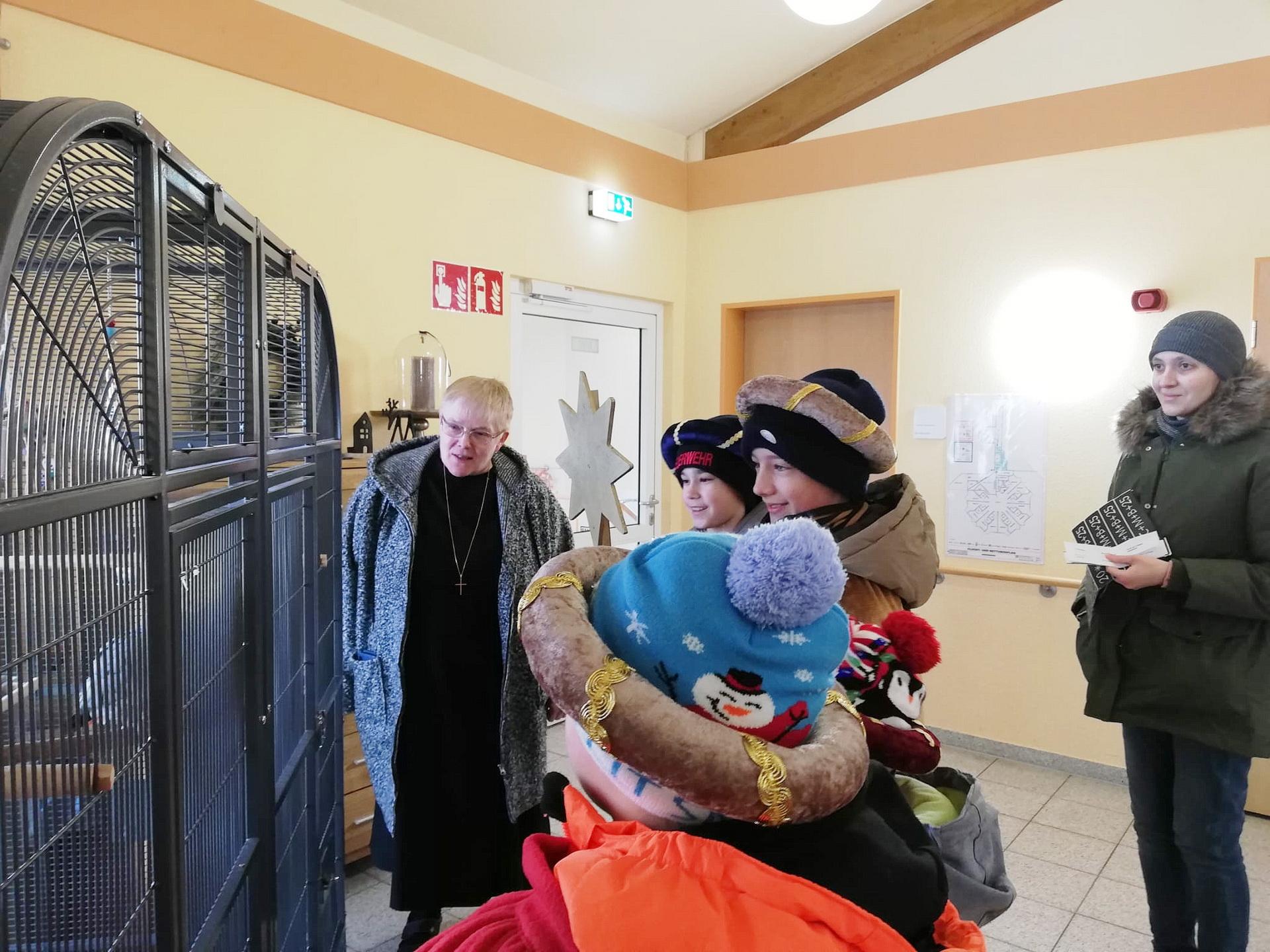 Im Hospiz „Stella Maris“ der Communio in Christo in Mechernich mit Schwester Lidwina vor dem Käfig von Papagei „Coco“ im Foyer: Begleiterin Angelina Meier, Emil Holzheim, Tino Stupning, Jonas und Jan Stupp.