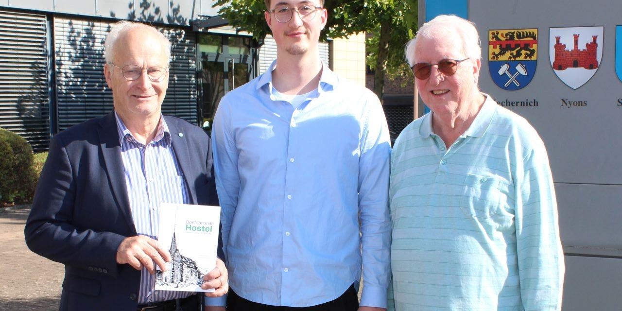 Das erste Exemplar für den ersten Bürger: Noch druckfrisch überreichte Autor Lucas Hamacher (Mitte) die nagelneue Dorfchronik zusammen mit Großvater Dieter Schröder (rechts) an Bürgermeister Hans-Peter Schick, der den 23-Jährigen zu den Recherchen über sein Heimatdorf Hostel ermutigt hatte.