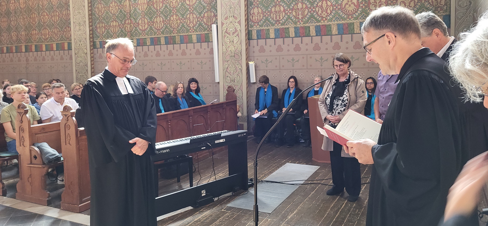 Synodalassessor Pfarrer Martin Obrikat aus Aachen (r.) entpflichtet den evangelischen Pfarrer Dr. Michael Stöhr, rechts im Hintergrund Stöhrs Ehefrau Sigrid Frentzen-Stöhr, die ebenfalls Pfarrerin ist. (c) Foto: Manfred Lang/pp/Agentur ProfiPress