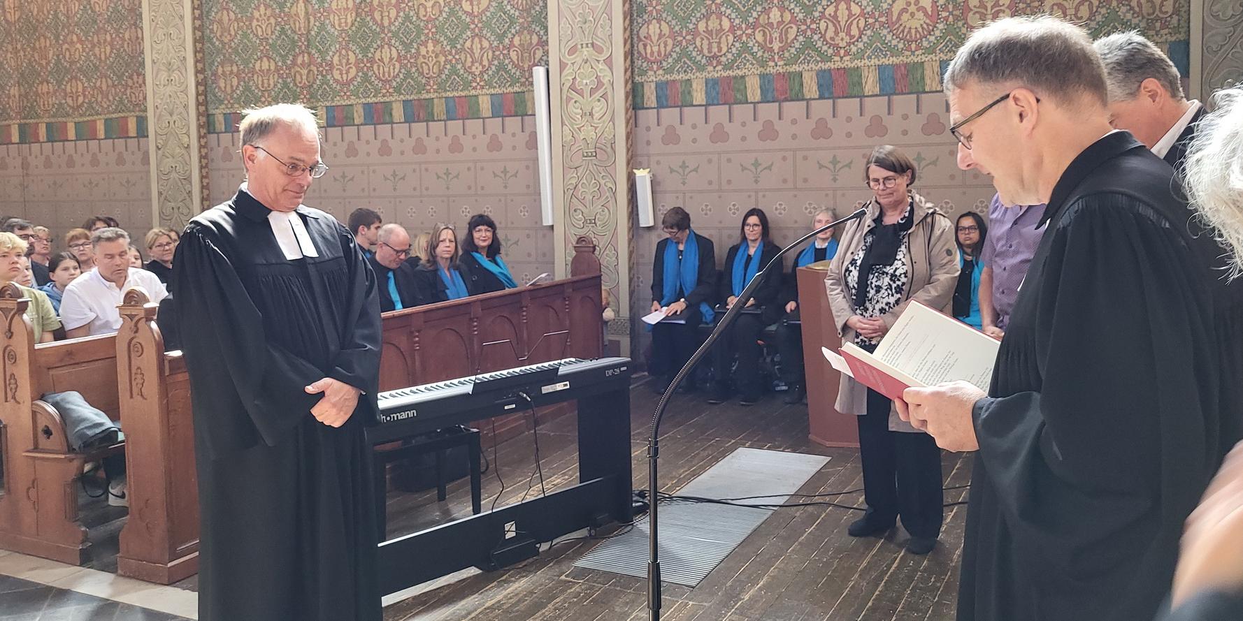 Synodalassessor Pfarrer Martin Obrikat aus Aachen (r.) entpflichtet den evangelischen Pfarrer Dr. Michael Stöhr, rechts im Hintergrund Stöhrs Ehefrau Sigrid Frentzen-Stöhr, die ebenfalls Pfarrerin ist.