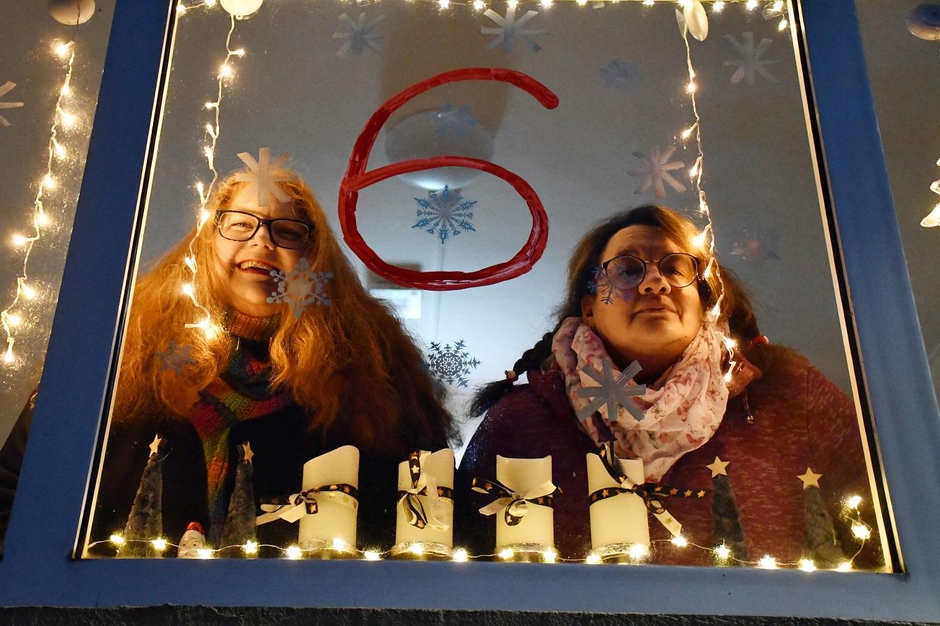 Initiatorin Sara Uedelhofen (v.l.) und Andrea Schröter von der Seniorenresidenz Marisa am Nikolaustag 2023 hinter Fenster Nummer 6 des Kalenberger Dorf-Adventskalenders.