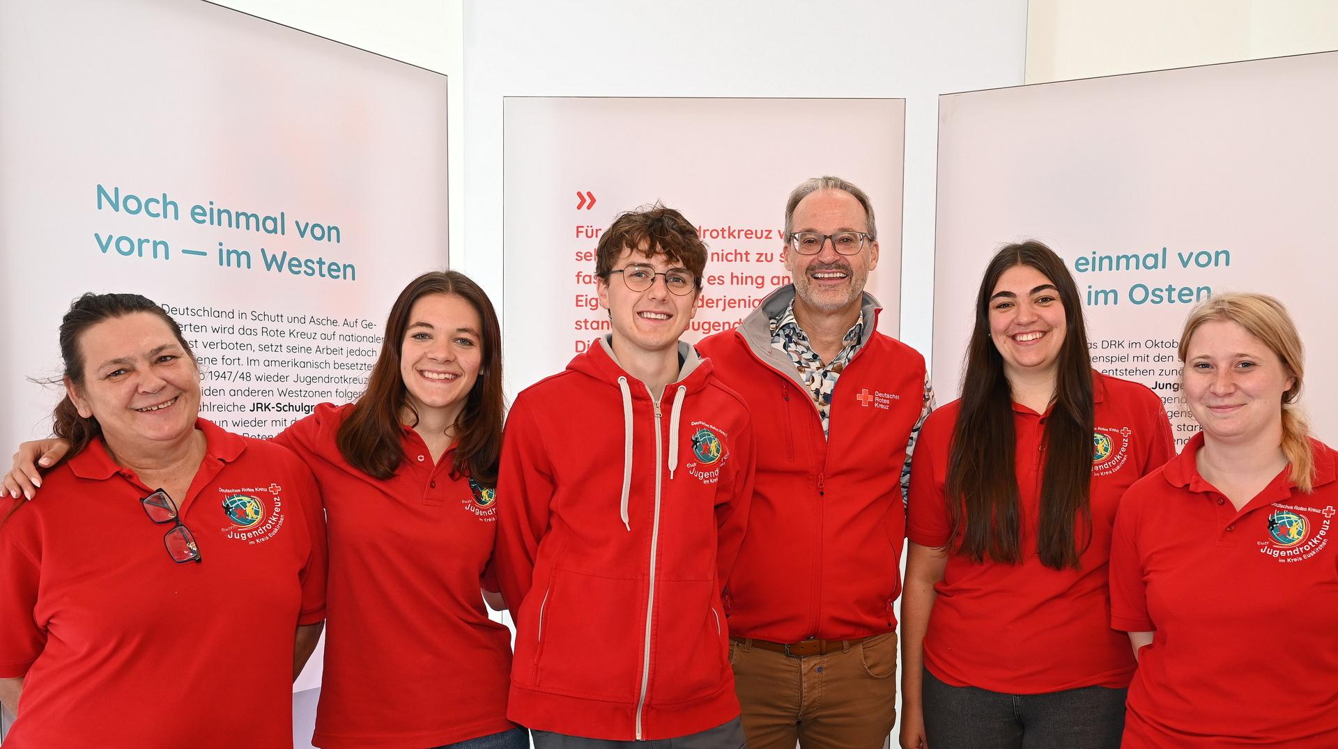 In der Ausstellung „100 Jahre Jugendrotkreuz“ (von links) die Hellenthaler Jugendrotkreuz-Ortsvereinsvorsitzende Monja Chudaska, ihre Kaller Kollegin Anika Lang, Till Voss von der JRK-Kreisleitung, DRK-Kreisgeschäftsführer Rolf Klöcker, der auch Ortsvereinsvorsitzender in Mechernich ist, die JRK-Kreisvorsitzende Jasmina Engel aus Kall, und Desiré Wollersheim, die Jugendrotkreuzchefin in Zülpich.