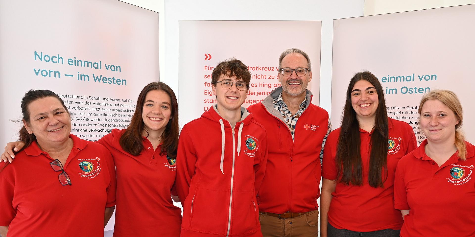 In der Ausstellung „100 Jahre Jugendrotkreuz“ (von links) die Hellenthaler Jugendrotkreuz-Ortsvereinsvorsitzende Monja Chudaska, ihre Kaller Kollegin Anika Lang, Till Voss von der JRK-Kreisleitung, DRK-Kreisgeschäftsführer Rolf Klöcker, der auch Ortsvereinsvorsitzender in Mechernich ist, die JRK-Kreisvorsitzende Jasmina Engel aus Kall, und Desiré Wollersheim, die Jugendrotkreuzchefin in Zülpich.