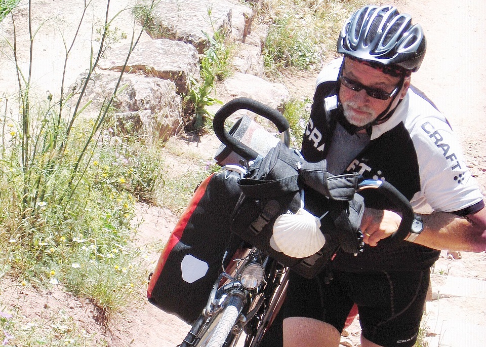 Wer sein Fahrrad liebt, schiebt – besonders an Steilhängen: Jakobspilger Robert Ohlerth 2014 auf dem portugiesischbn „Camino“ zum Apostelgrab in Santiago de Compostela. (c) Foto: Privat/pp/Agentur ProfiPress