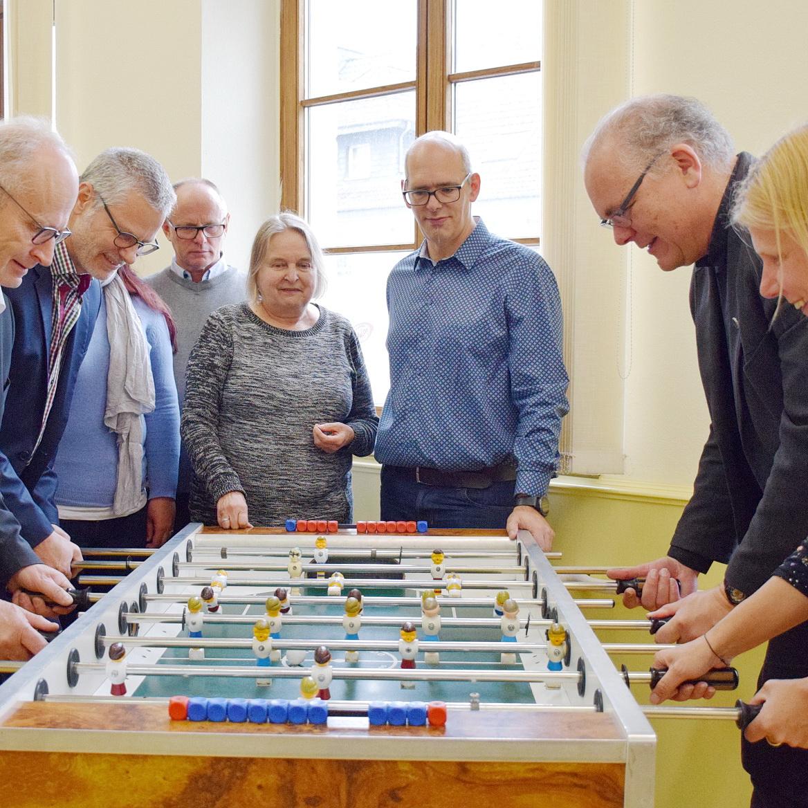 In der Kleinen Offenen Tür von Stadt und Kirche gehts rund, nicht nur beim Kickerspiel der Offiziellen bei der Eröffnung, links Bürgermeister Dr. Hans-Peter Schick, rechts K.O.T.-Leiterin Anja Lehmann und Pfarrer Erik Pühringer.