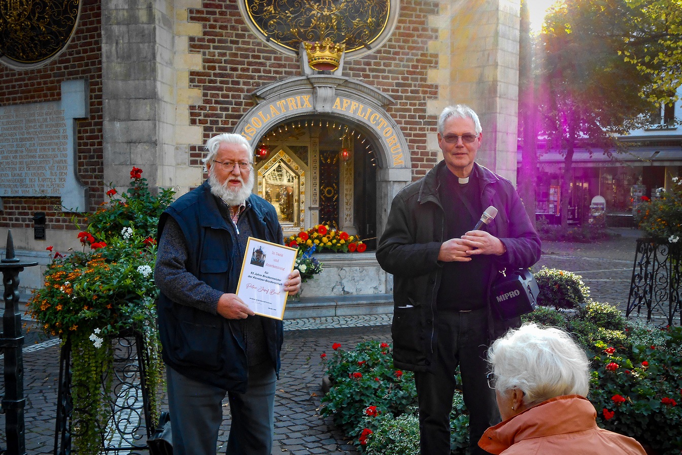 Vor dem Gnadenbild wurde Peter Beul (l.) für 65 Jahre Brudermeister der Kevelaer-Bruderschaft ausgezeichnet. Als Dank überreichte Pfarrvikar Michael Haupt eine Urkunde. (c) Foto: privat/pp/Agentur ProfiPress