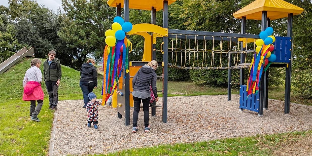 Kinder erobern das neue, zur Einweihung mit Luftballons verzierte Klettergerüst auf dem Holzheimer Mehrgenerationenplatz.