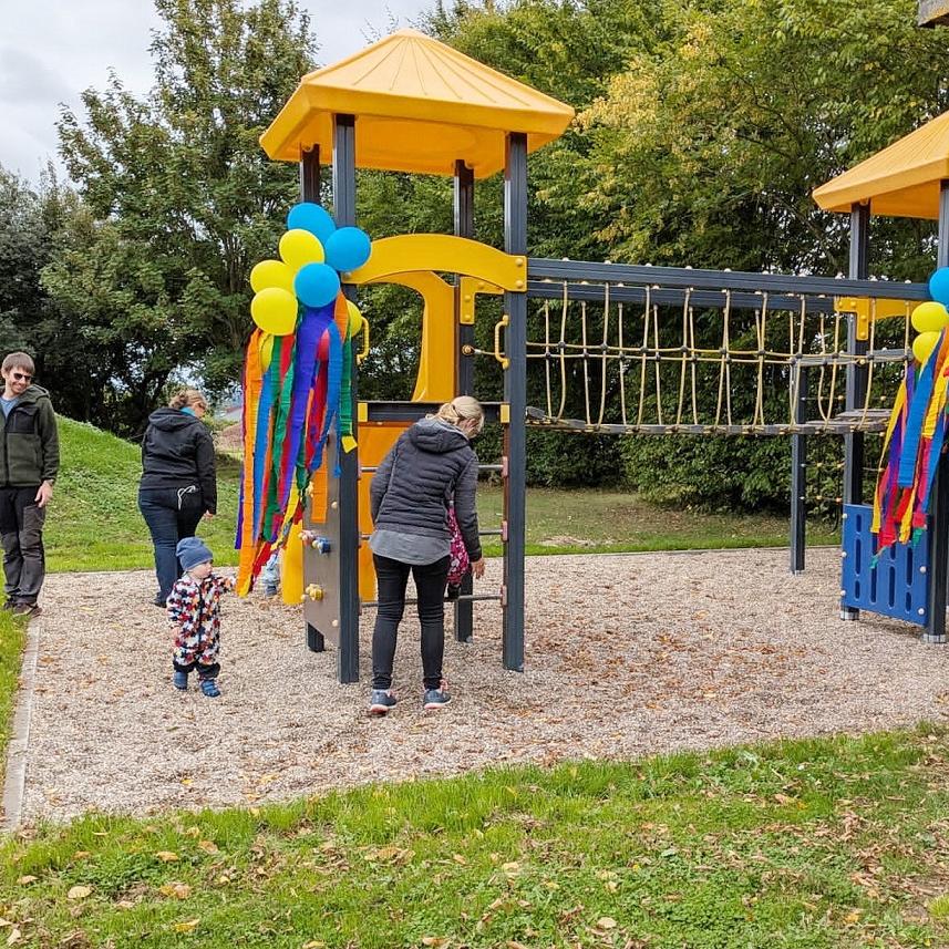 Kinder erobern das neue, zur Einweihung mit Luftballons verzierte Klettergerüst auf dem Holzheimer Mehrgenerationenplatz.