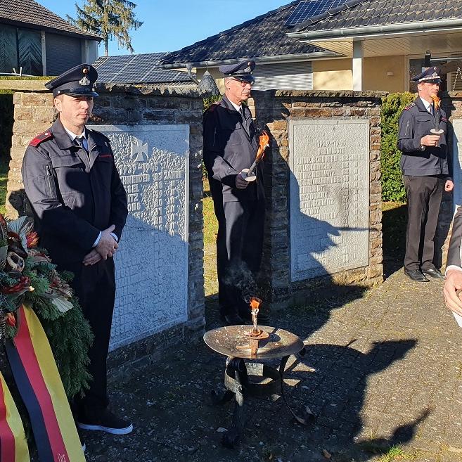 Ortsbürgermeister Björn Wassong legt mit Feuerwehrkameraden einen Kranz am Weyerer Ehrenmal für die Opfer von Krieg, Gewalt, Unrechtsherrschaft und Terrorismus nieder.