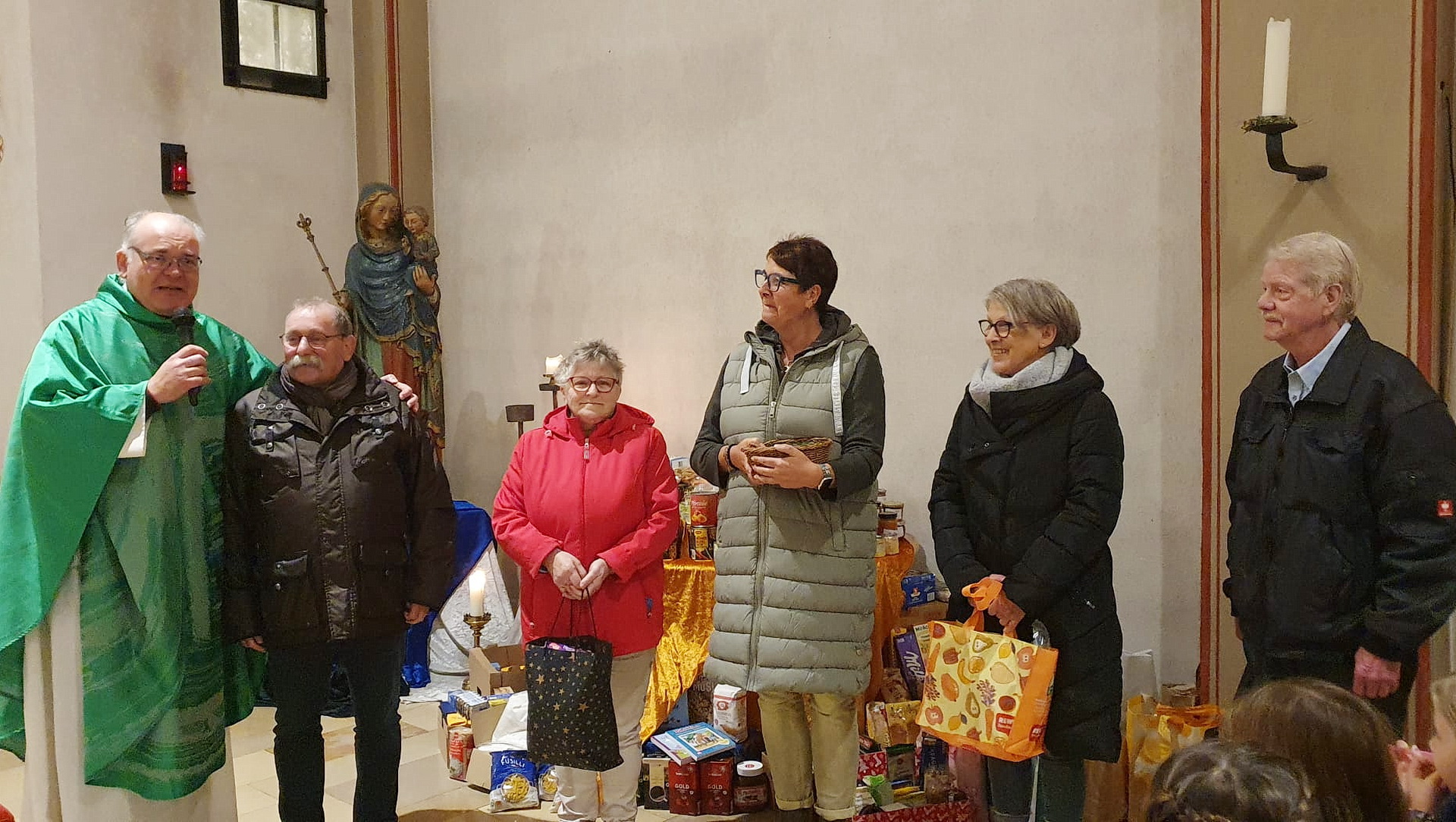Pfarrer Erik Pühringer und „Tafel“-Chef Wolfgang Weilerswist (v.l.) mit weiteren Vorständen der Mechernicher Wohltätigkeitsorganisation mit gespendeten Lebensmitteln der Gemeindemitglieder am Altar der Pfarrkirche St. Johannes Baptist. (c) Archivfoto: pp/Agentur ProfiPress
