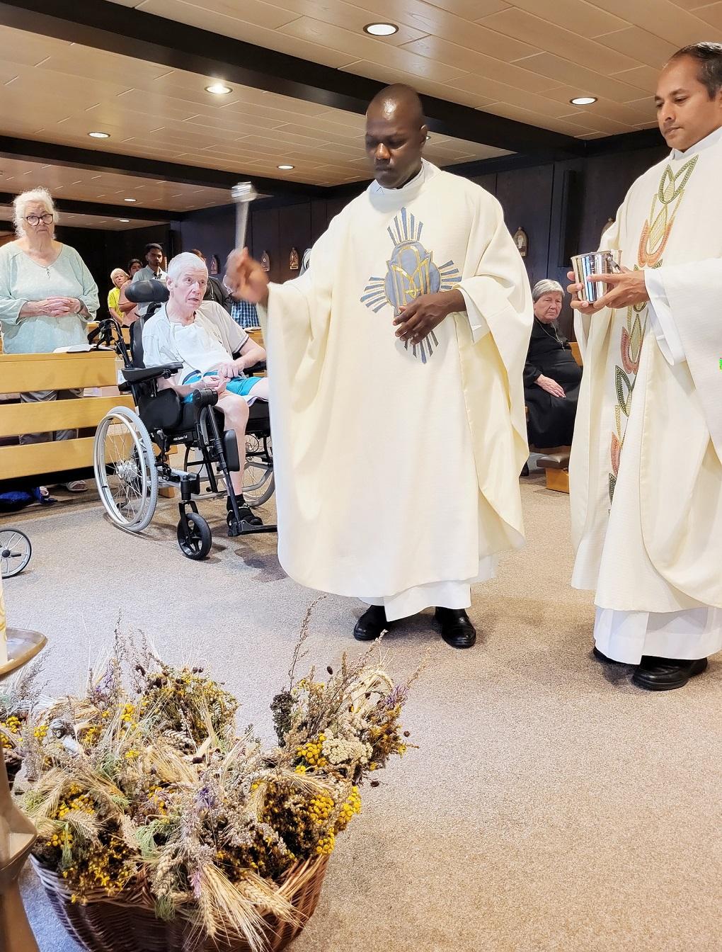 Father Patrick Mwanguhya segnete mit Generalsuperior Pfarrer Jaison Thazhathil an seiner Seite zur Feier des Tages über 30 Krautwische, eine eintausendeinhundert Jahre alte Sakramentalie der katholischen Kirche.