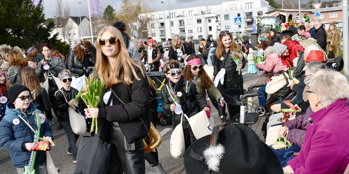 „Mir schenken der Ahl e paar Blöömcher“: Kinder und Jugendliche der katholischen „Rockergruppe“ im Zug verteilen Tulpen und „Strüßjer“ vor dem Seniorenstift Kreuser.