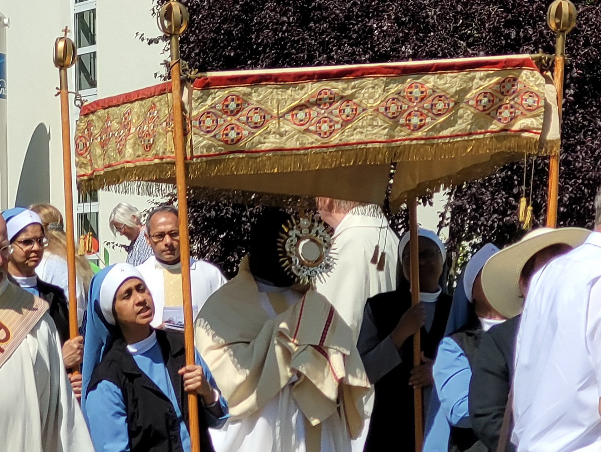 Der ugandische Priester Patrick Mwanguhya trägt das Allerheiligste in der Monstranz, indische Samaritan-Ordensschwestern tragen den „Himmel“, im Hintergrund Pfarrer Erik Pühringer und Generalsuperior Jaison Thazhathil. (c) Foto: Sabine Roggendorf/pp/Agentur ProfiPress