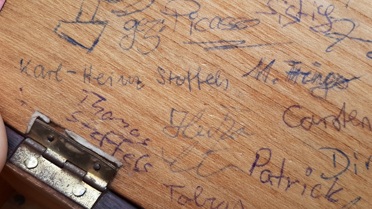 Auf der Holzkassette, die den „Brabbelern“ als Kasse dient, haben sich Heischegänger aus Jahrzehnten „verewigt“. Auch die Unterschrift des heutigen Pater Elias von Maria Laach, Karl-Heinz Stoffels, ist zu finden. (c) Foto: Reiner Züll/pp/Agentur ProfiPress