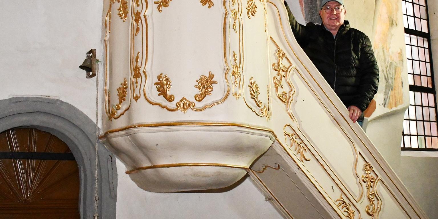 Der Predigtstuhl in der alten Kirche von Mechernich hatte einst seinen Platz in der Schlosskapelle des Hauses Rath zwischen Strempt und Roggendorf. Auf der Treppe ist der frühere Geschäftsführer des Kirchengemeindeverbandes Mechernich, Bertram Jannes, zu sehen, der den Mechernicher „Bürgerbrief“ auf eine interessante Kirchengeschichte aufmerksam machte.