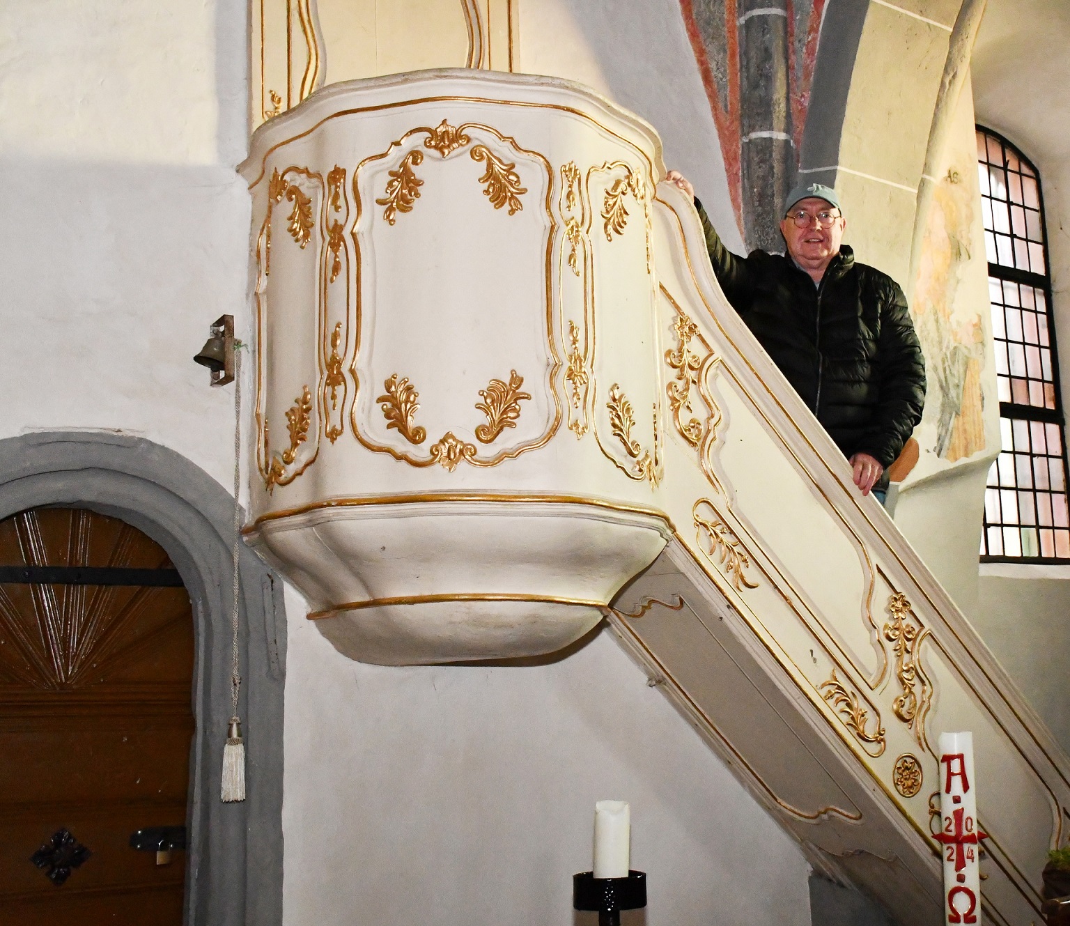 Der Predigtstuhl in der alten Kirche von Mechernich hatte einst seinen Platz in der Schlosskapelle des Hauses Rath zwischen Strempt und Roggendorf. Auf der Treppe ist der frühere Geschäftsführer des Kirchengemeindeverbandes Mechernich, Bertram Jannes, zu sehen, der den Mechernicher „Bürgerbrief“ auf eine interessante Kirchengeschichte aufmerksam machte. (c) Foto: Sabine Roggendorf/pp/Agentur ProfiPress