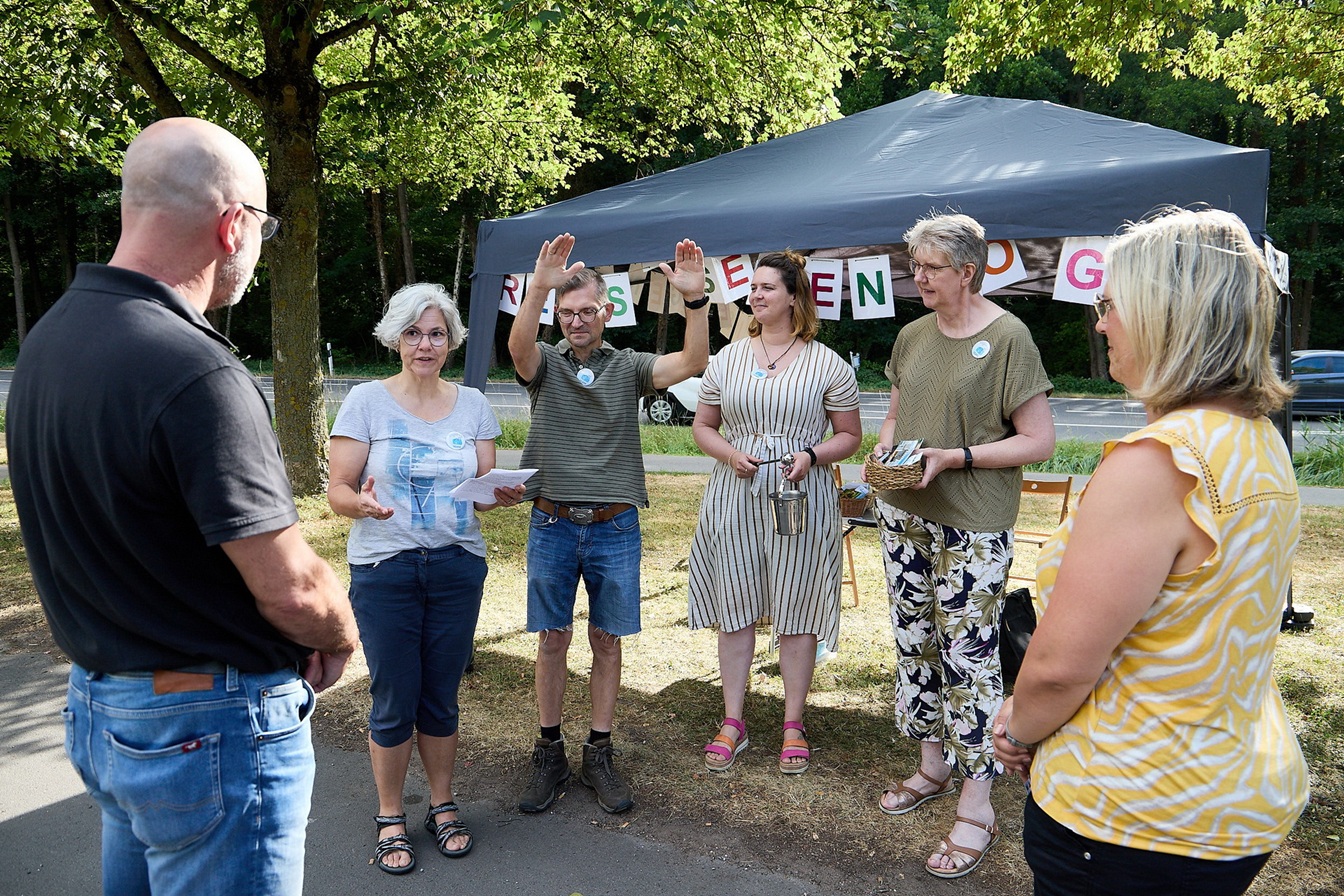 Den „Reisesegen to go“ empfingen Antje und Günter Schmitz (v.l.) am Mechernicher Mühlenpark von Pfarrerin Susanne Salentin, Sven Clouth, Pastoralreferentin Linda Schmitt-Thees und Martina Schürmann. (c) Foto: Stephan Everling/RRG/pp/Agentur ProfiPress