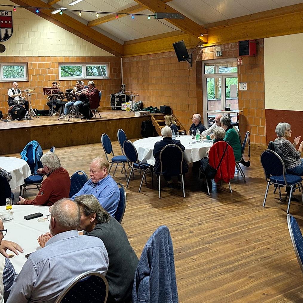 Bei Kaffee, Kuchen und Musik: Zahlreiche Seniorinnen und Senioren genossen den gemütlichen Nachmittag in der Weyerer Bürgerhalle. Im Hintergrund sorgt der Musikverein „Harmonie Weyer“ mit Blasmusik für gute Stimmung.