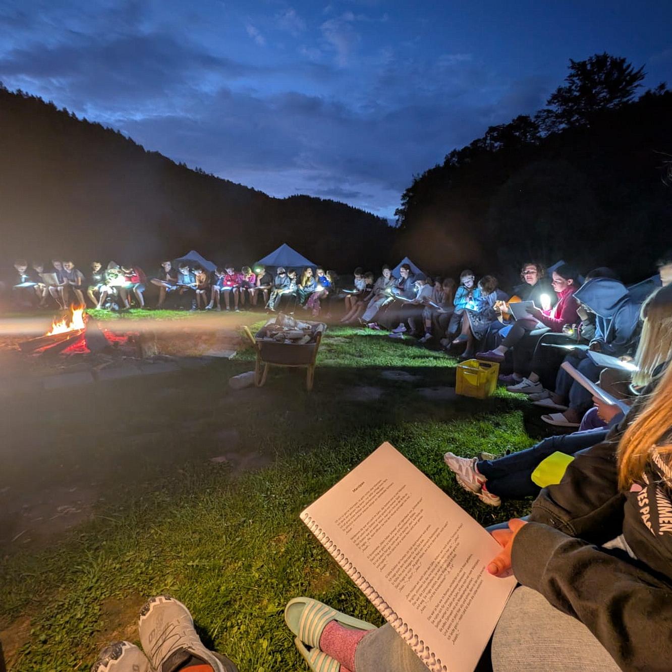Abendliches Singen am Lagerfeuer im Camp St. Agnes 2025 auf den Rurtalwiesen bei Dedenborn.