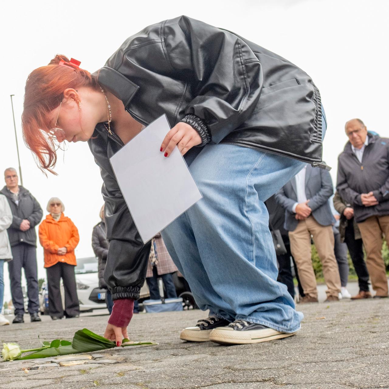 Eine Schülerin der Gesamtschule Mechernich legt eine Rose an die Stolpersteine von Dr. Robert und Bertha David, die in der Bahnstraße lebten. Insgesamt acht Gedenksteine wurden jetzt in Mechernich verlegt. Foto: Ronald Larmann/pp/Agentur ProfiPress